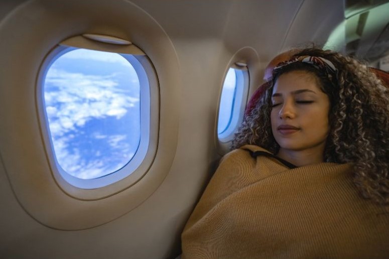 Mulher dormindo com conforto durante o voo