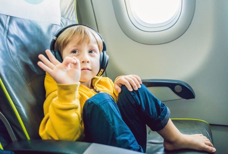 Criança com fones de ouvido confortável no voo