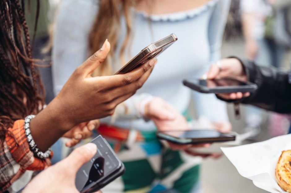 jovens com celulares nas mãos redes sociais